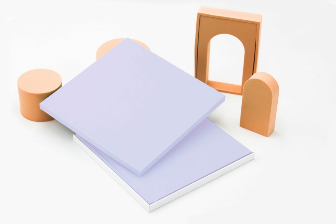 An open lilac-coloured square presentation box with a photobook of the same colour inside